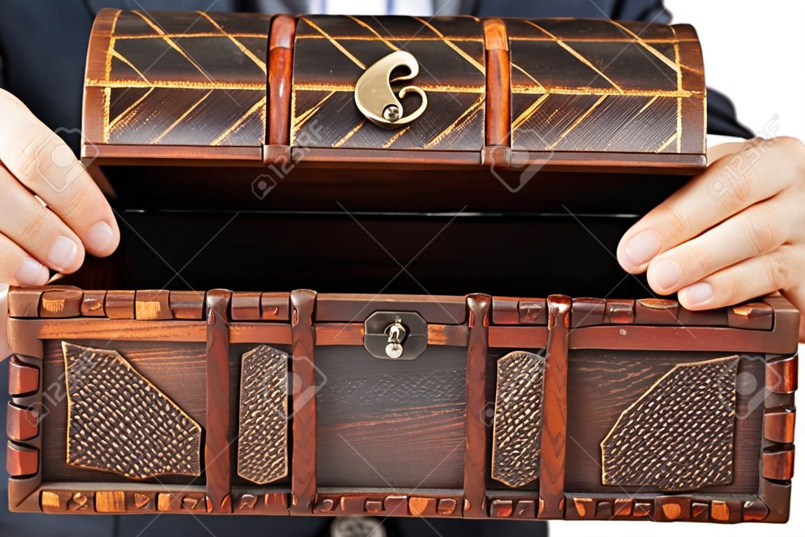 Hombre de negocios la celebración de la mano de edad antigua madera de color marrón en el pecho o la caja del tesoro blanco aislado