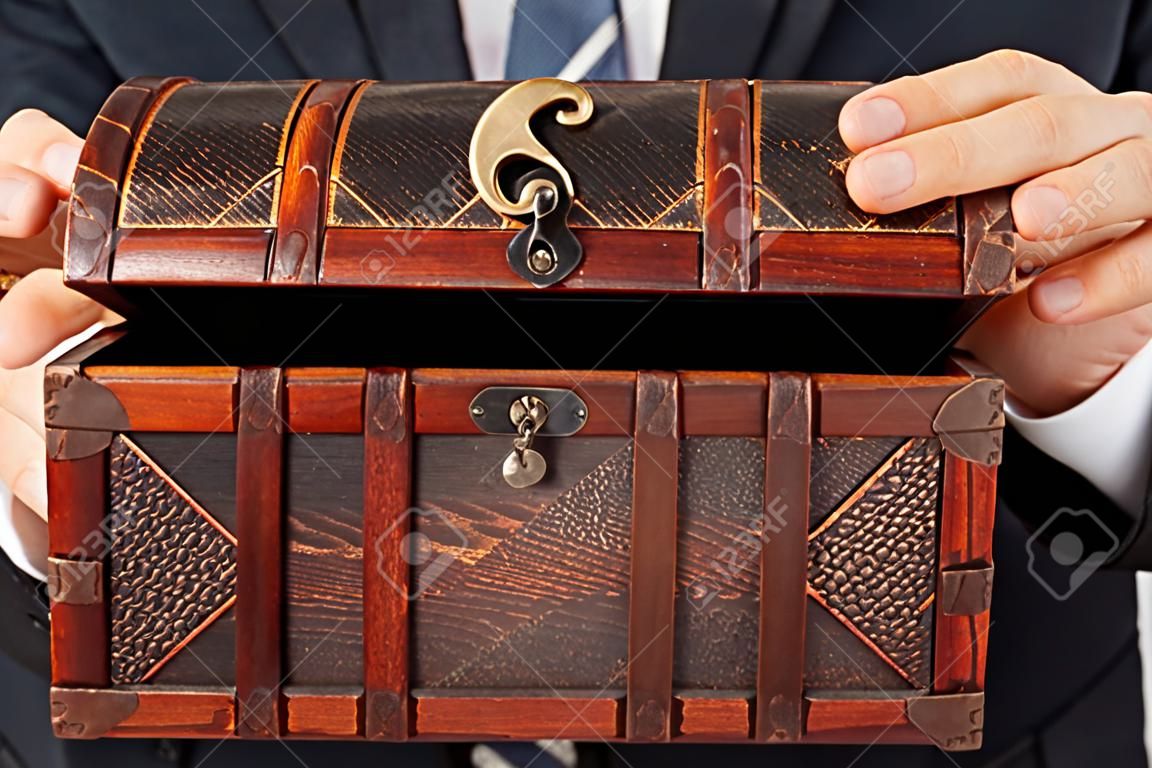 Business-Mann Hand antiken braunen Holz Schatztruhe oder Box weiß isoliert