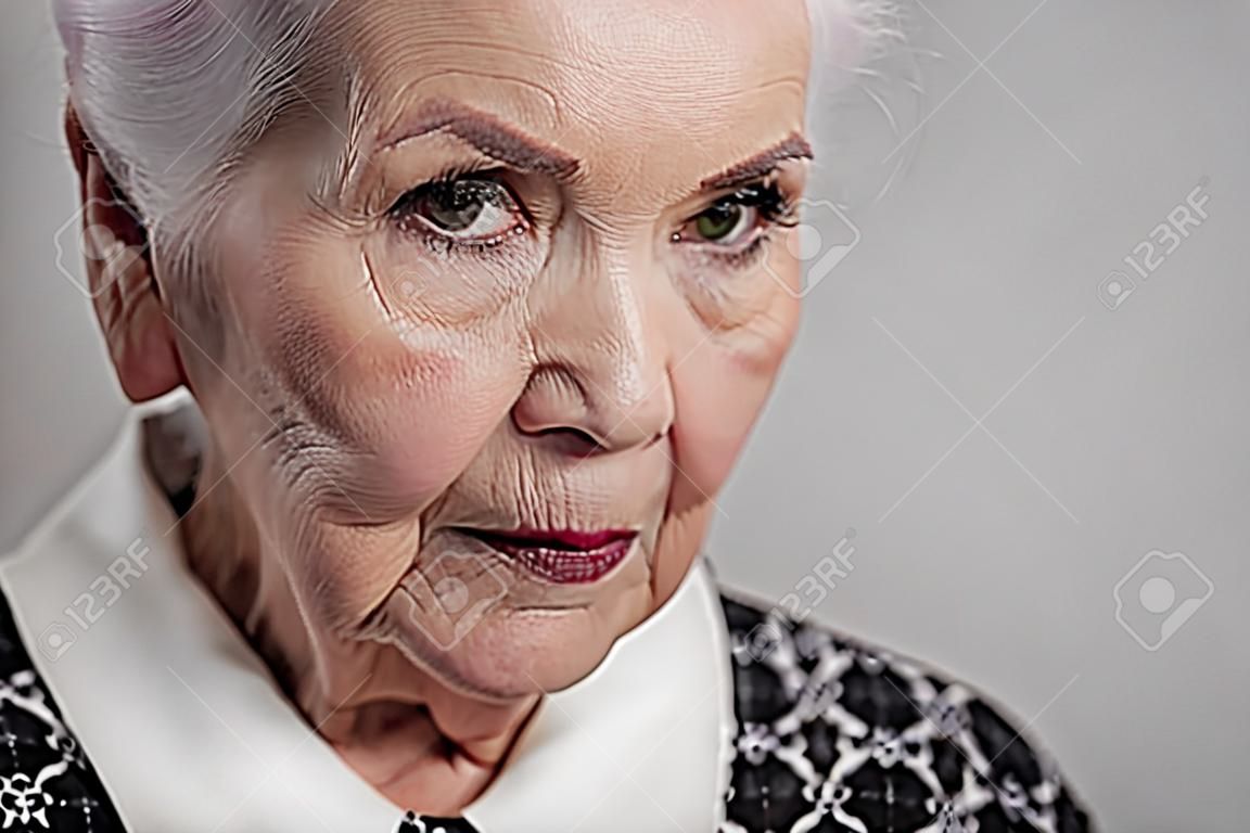 Serious elderly female looking at camera
