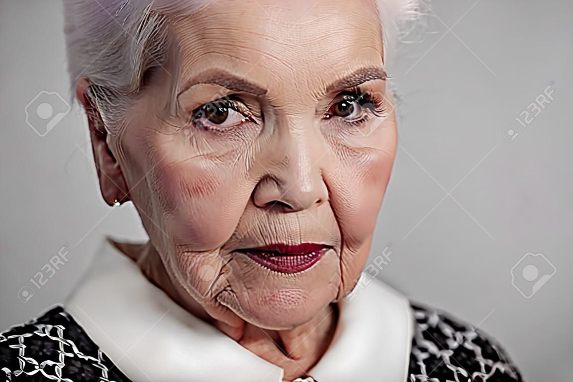 Serious elderly female looking at camera