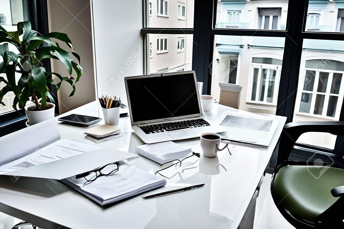 Verschillende documenten, moderne laptop situeren op witte tafel in modern kantoor. Design concept