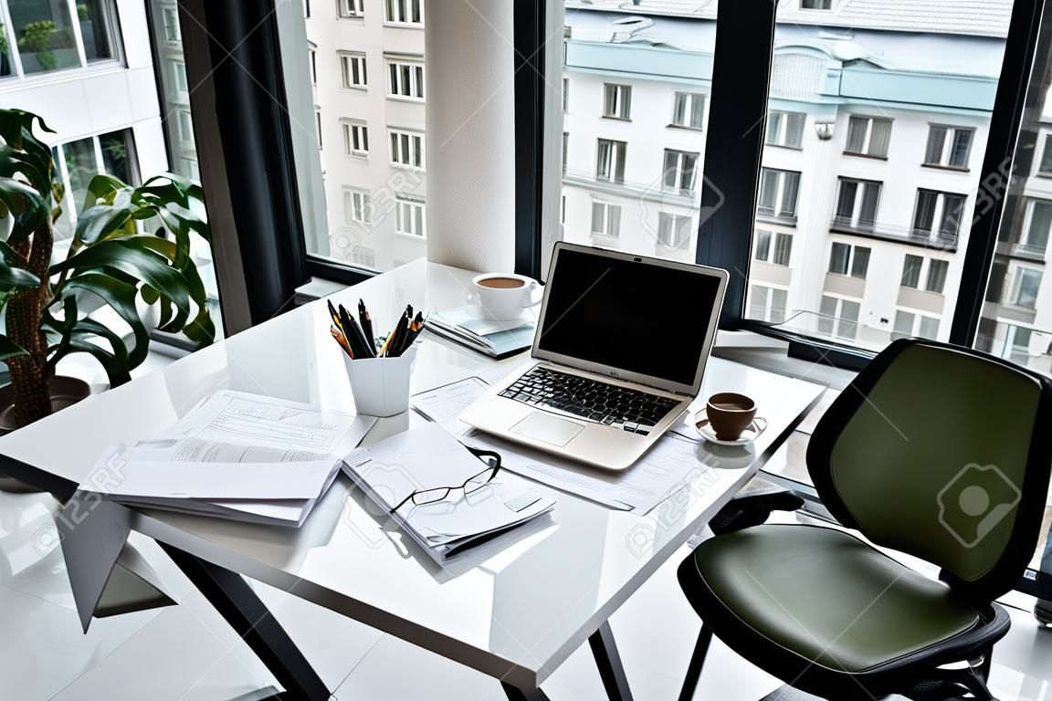 Verschillende documenten, moderne laptop situeren op witte tafel in modern kantoor. Design concept