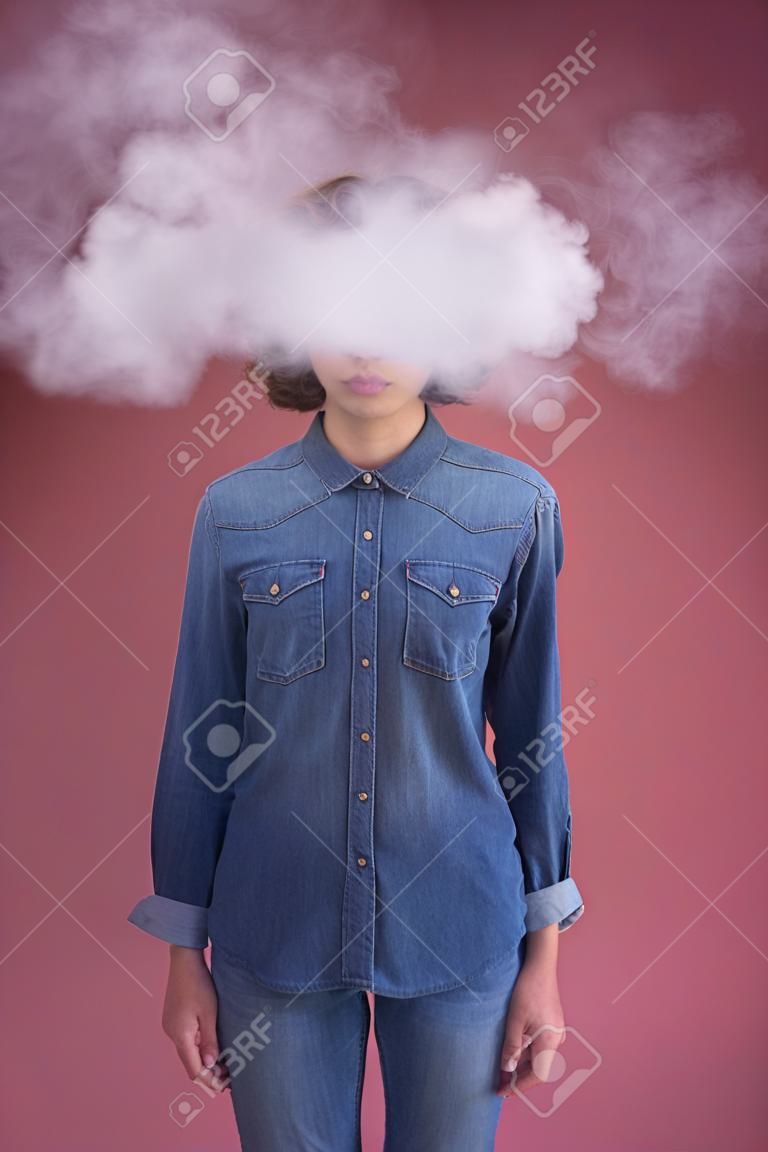 Serious young woman is standing while having smoke around her head. Excess of information concept. Isolated