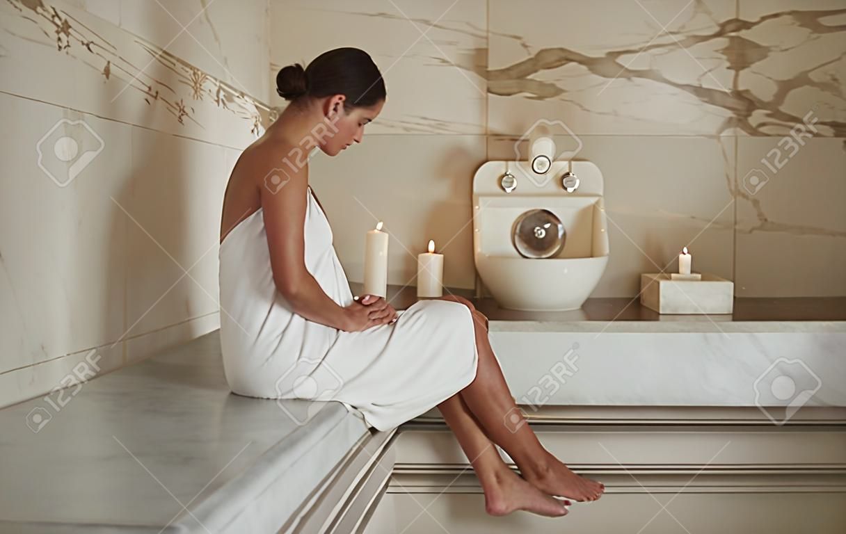 Woman in hammam. Peaceful dark haired lady showing her beautiful legs and looking calm at hammam procedure