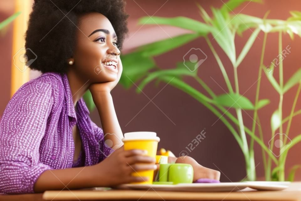 Close up of cheerful young African woman having rest in cafeteria