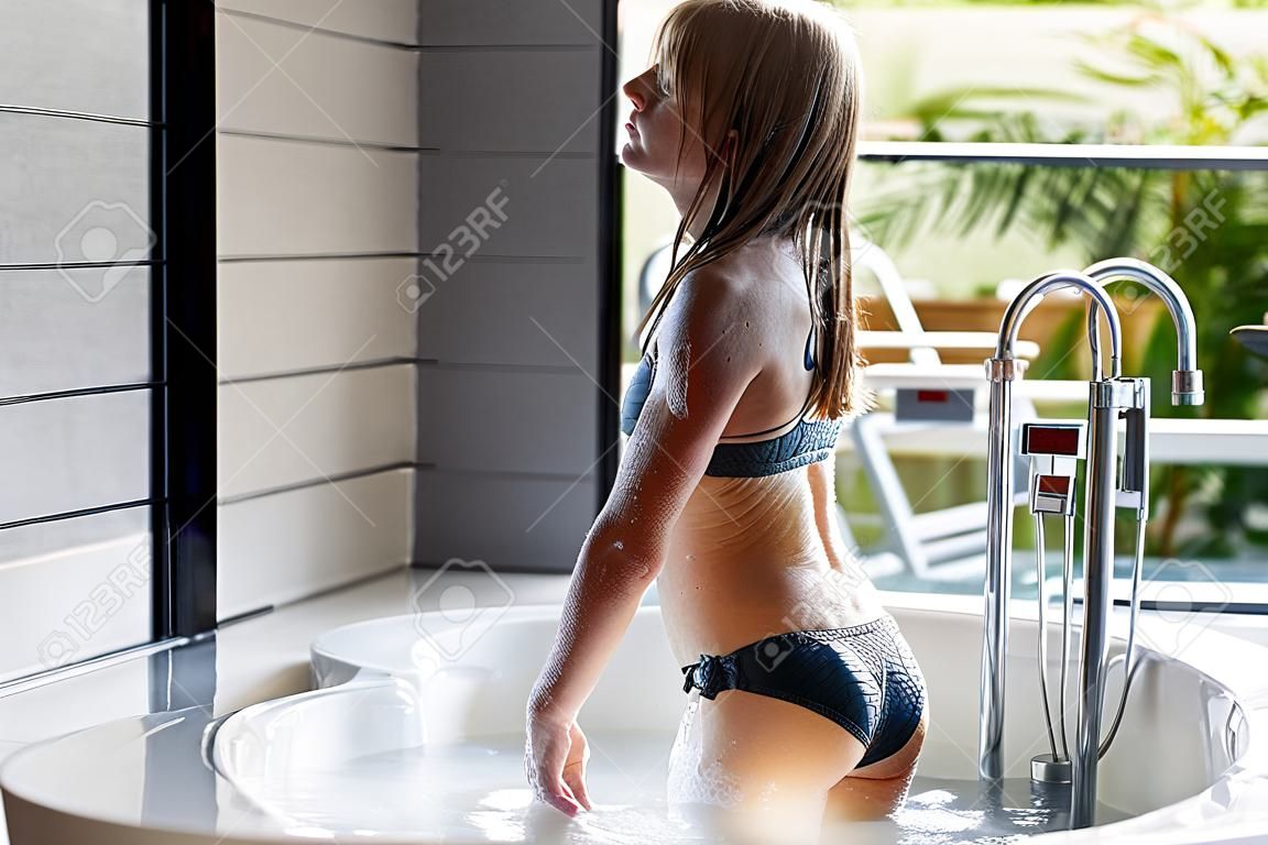 Menina em traje de banho em pé no banho
