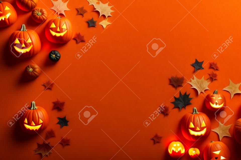 Halloween pumpkins on orange background. Top view, copy space
