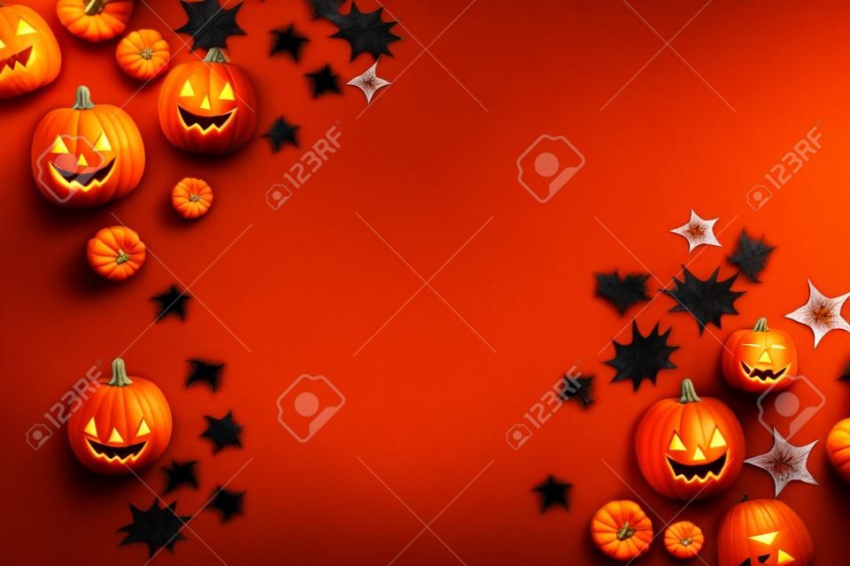 Halloween pumpkins on orange background. Top view, copy space