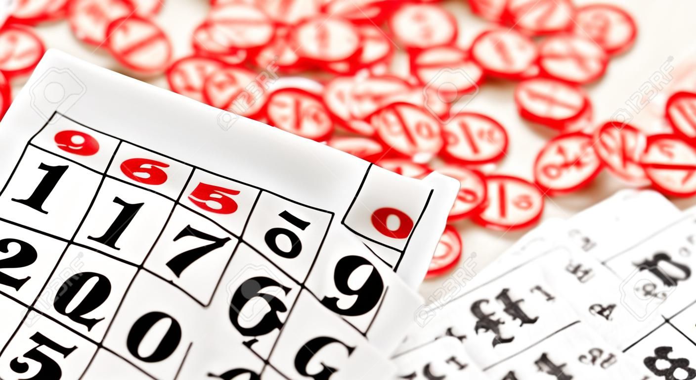 Molti trucioli di legno con numeri e carte per un gioco da tavolo di bingo o lotto su sfondo chiaro. il lotto russo ha regole simili al classico gioco del bingo mondiale.