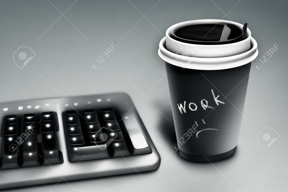 tastiera nera e una tazza di caffè. l'iscrizione sul bicchiere di carta.