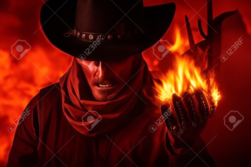 Foto de uma cabeça de crânio demoníaco cowboy em chapéu segurando feitiço de fogo com o braço em um fundo do deserto do pôr do sol.