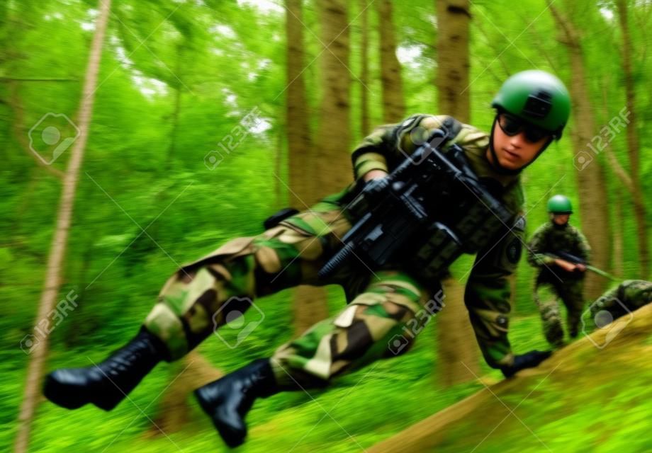 완벽한 장비를 갖춘 군인들이 숲에서 소총을 들고 점프하고 달리는 사진.
