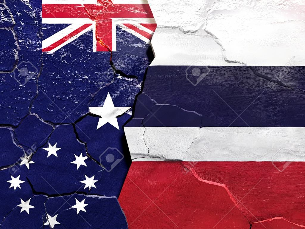 ひびの入ったコンクリートにタイとオーストラリアの旗（国際紛争の概念）