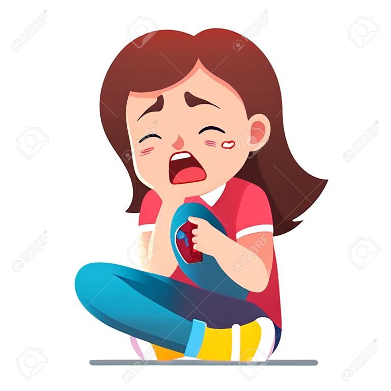 Petite fille assise pleurant de douleur au genou blessé