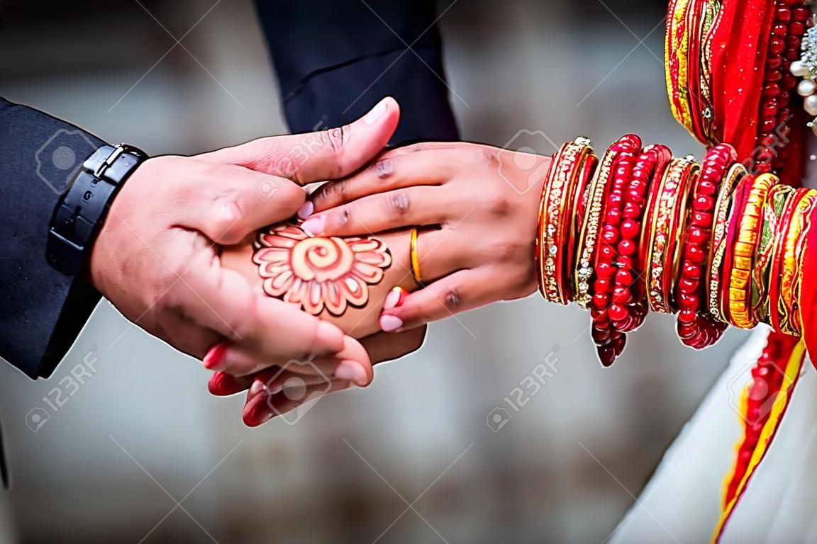 Young adult male groom and female bride holding hands together,Hands of newlywed couple.