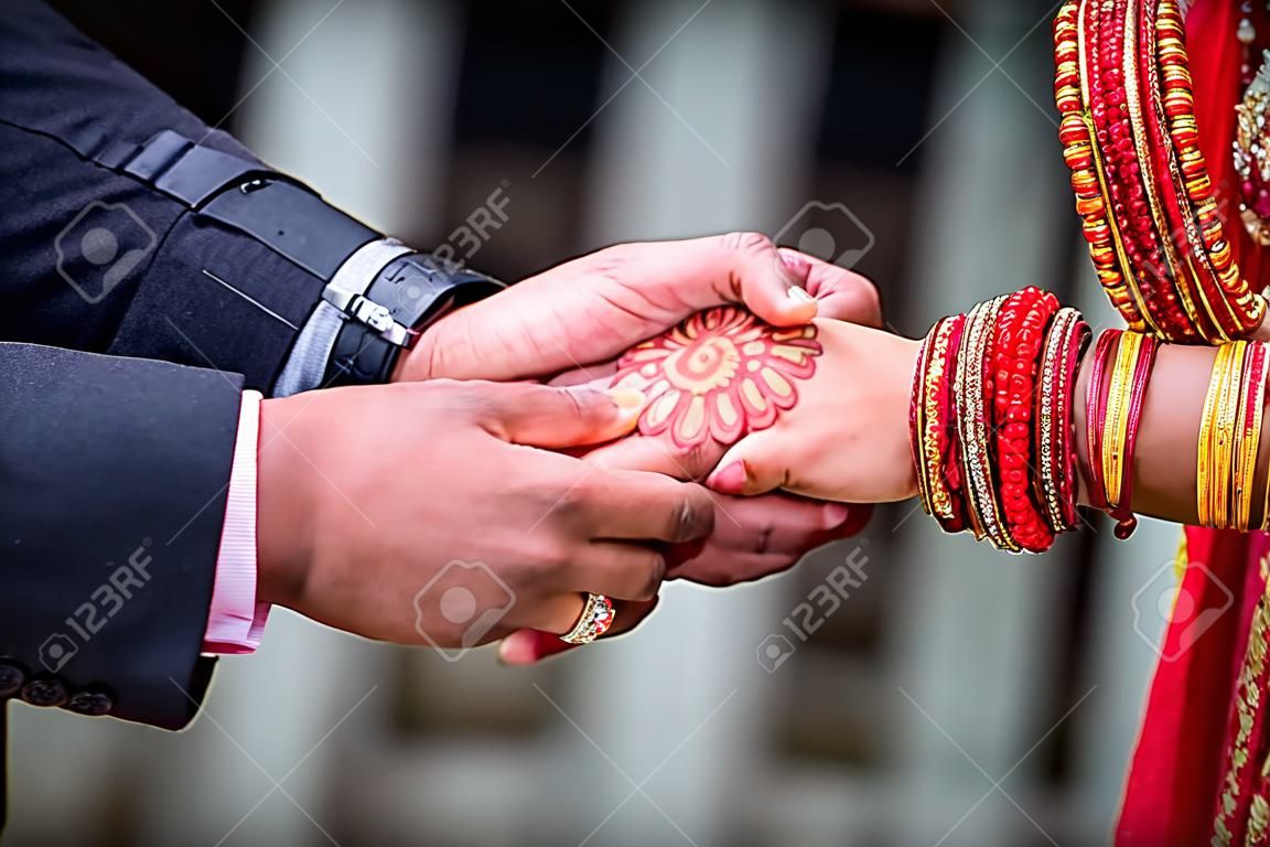 Junger erwachsener männlicher Bräutigam und weibliche Braut, die Händchen halten, Hände des frisch vermählten Paares.
