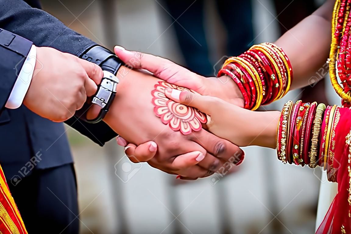 Junger erwachsener männlicher Bräutigam und weibliche Braut, die Händchen halten, Hände des frisch vermählten Paares.