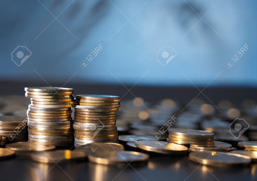 Banche e commercio di denaro. Monete di metallo dorato impilate in diverse combinazioni su sfondo sfocato blu scuro. Moneta di metallo serba, spazio di copia