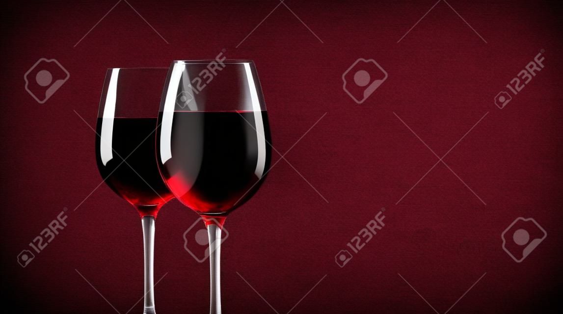 glasses with red wine against of color background.