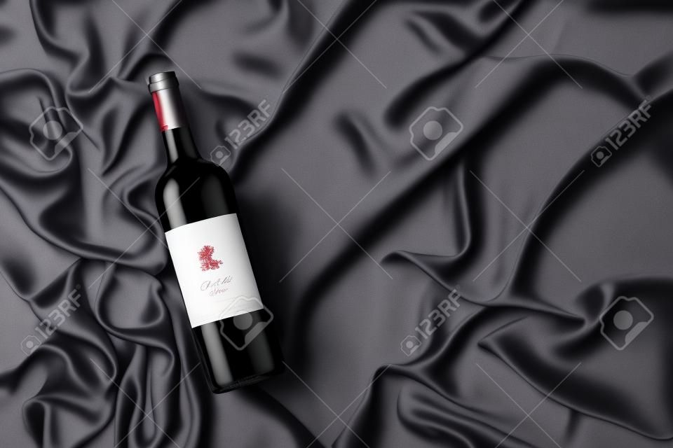 Bottiglia di vino rosso con etichetta vuota su sfondo grigio satinato. vista dall'alto.