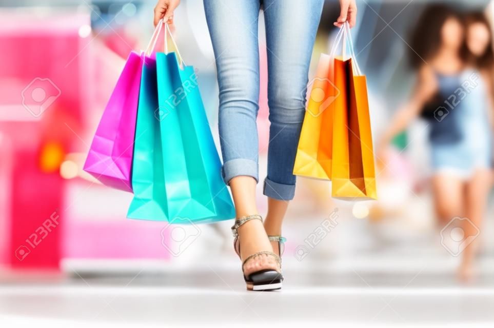 여성의 다리는 쇼핑몰 센터에서 쇼핑을 즐기고, 손을 잡고 쇼핑, 구매 및 쇼핑 소비주의, 여름 할인 매장에서 쇼핑을 즐깁니다.