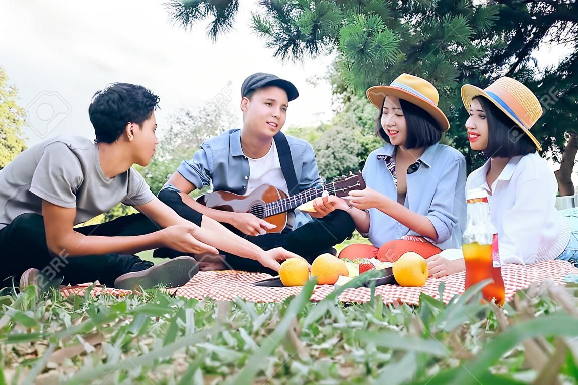 Young teen groups having fun picnic in park together. Relax and Leisure activity.
