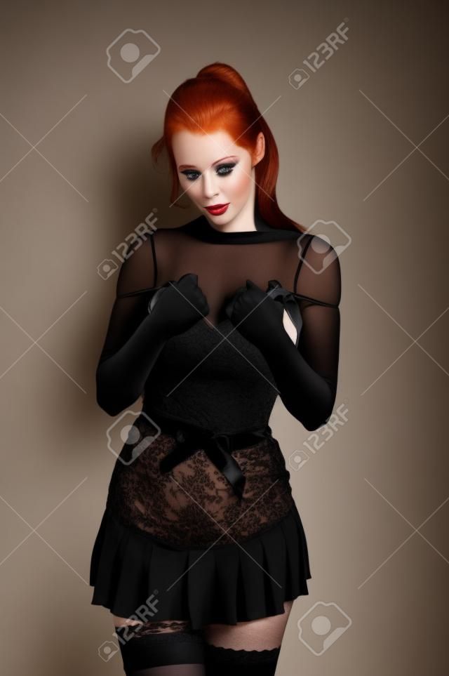 美しい赤毛の短い黒のドレスとストッキングを身に着けています。