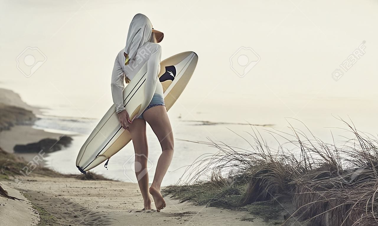 Gyönyörű női szörfös keres a hullámok