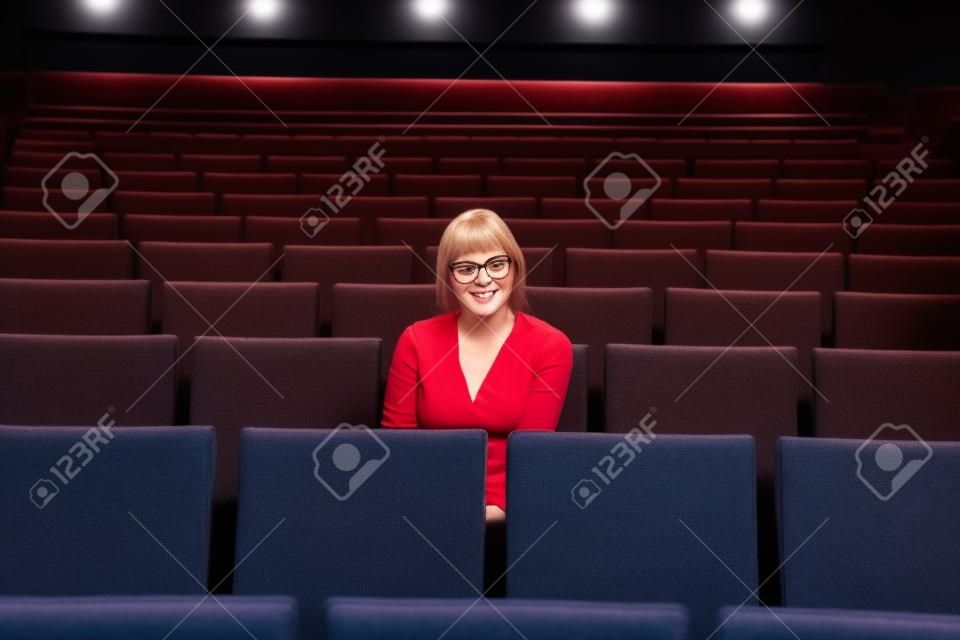 Mujer soltera sentado solo en un cine o teatro vacío