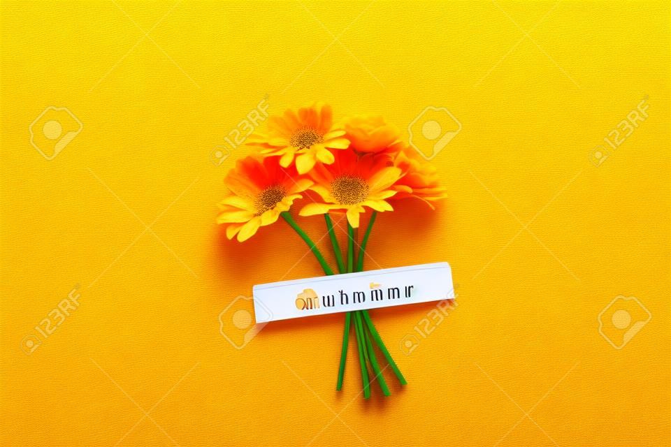 Calendar autumn month October and orange flowers on green background. Top view Flat lay. Minimal concept Hello fall. Template for your design, greeting card.