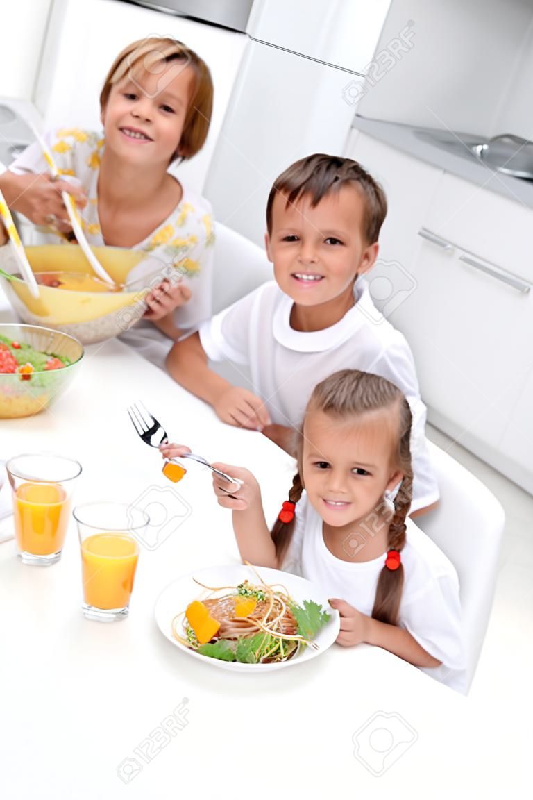 Morning in the kitchen - woman and kids eating healthy breakfast