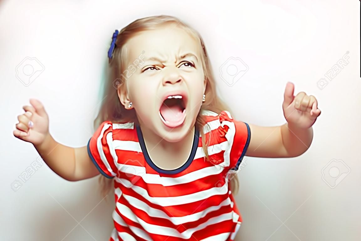 Boos klein meisje toont haar tong in grappige grimmigheid