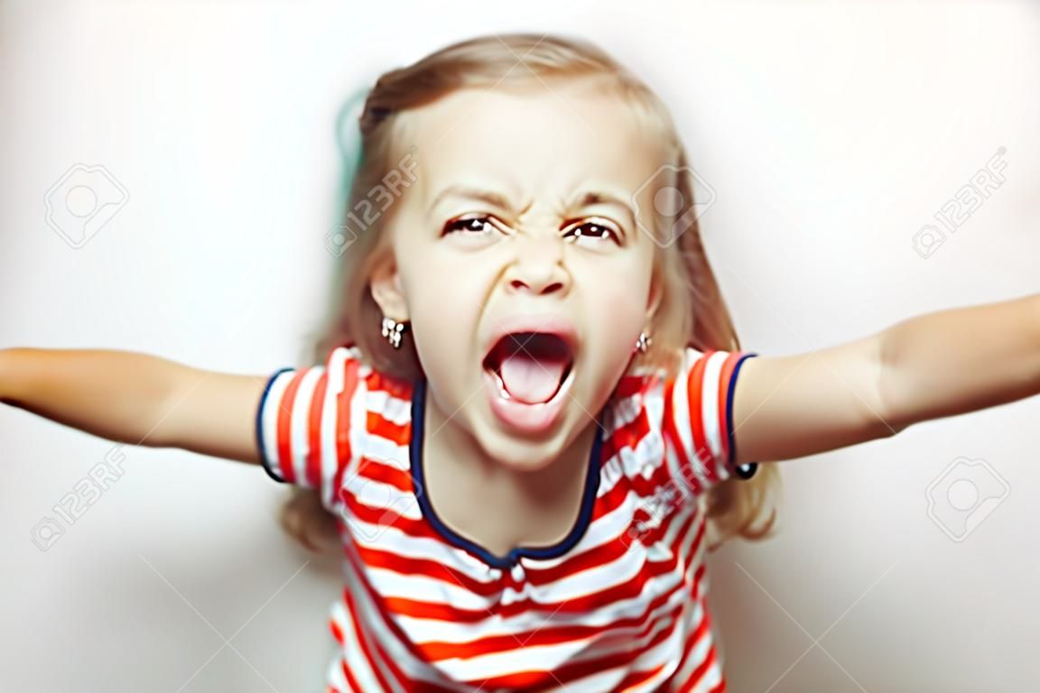 Verärgertes kleines Mädchen zeigt ihre Zunge in lustige Grimasse