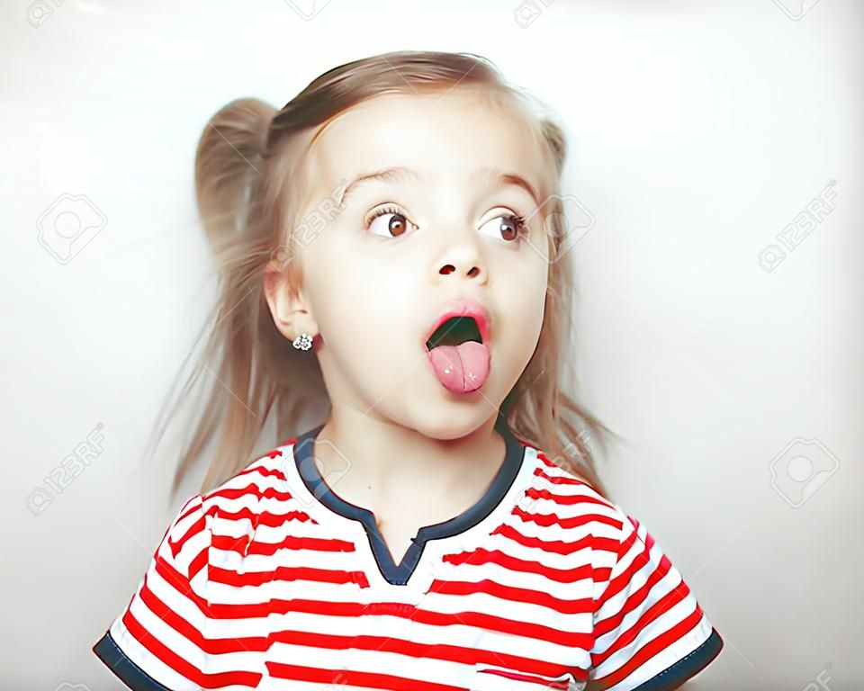 Adorablr小女孩伸出舌頭，側身看