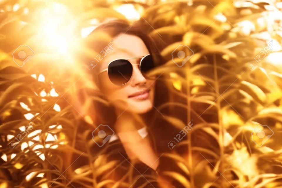 En la mujer con gafas de sol señaló la luz del sol.