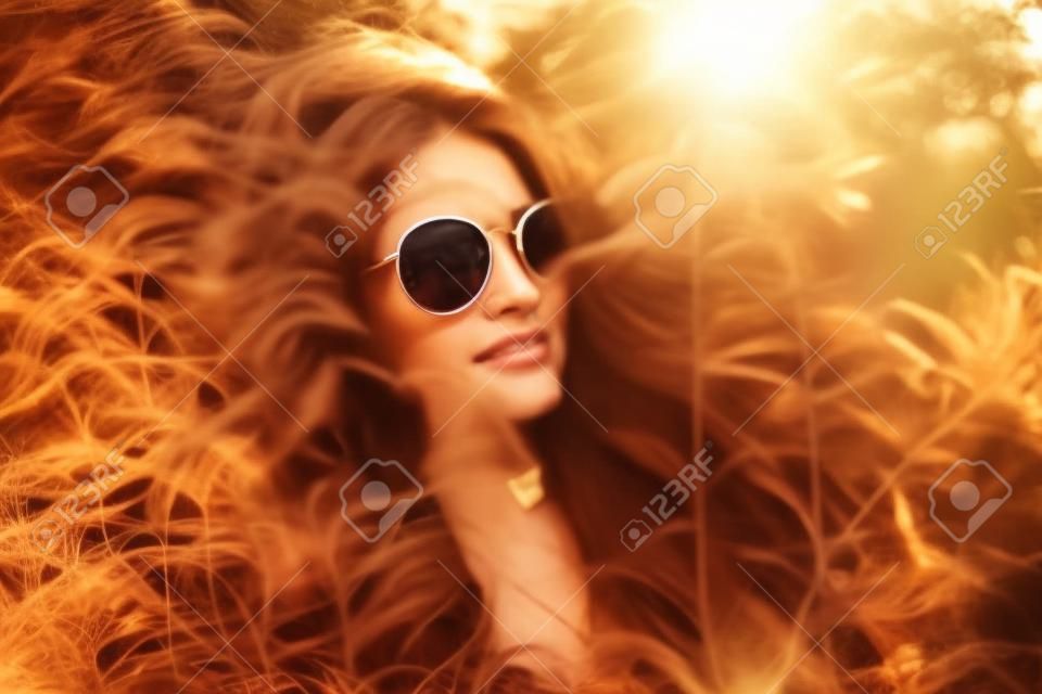 Na kobiecie w okularach przeciwsłonecznych wskazał światło słoneczne.