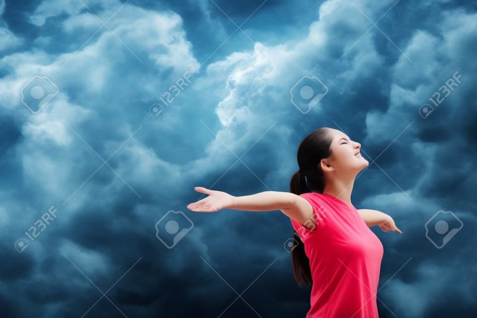 Woman with arms outstretched and eyes closed