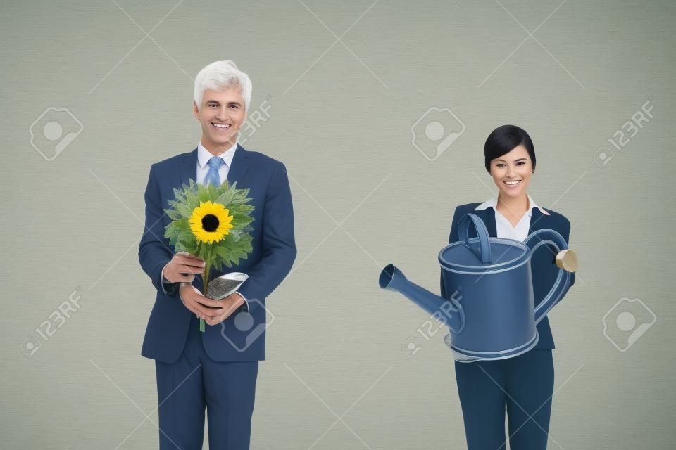 Unternehmer, die Blume während Geschäftsfrau hält eine Gießkanne