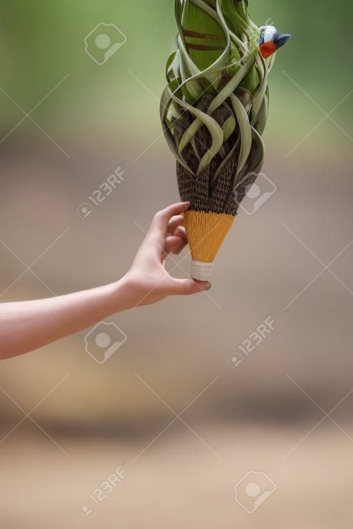 Human hand holding up a shuttlecock