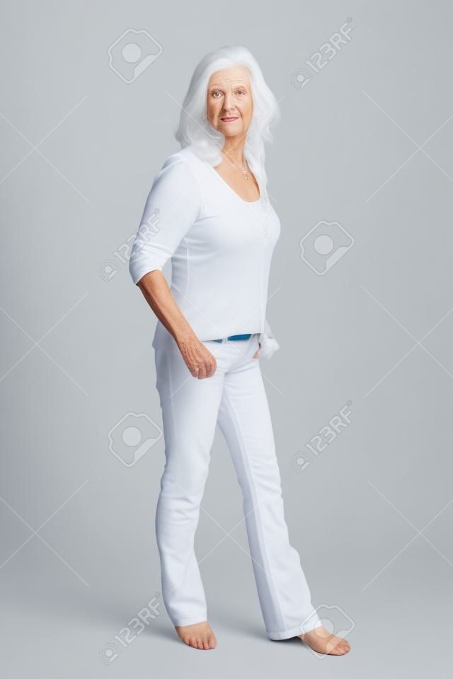 Ältere Frau, die isoliert auf weiß in voller Körperlänge
