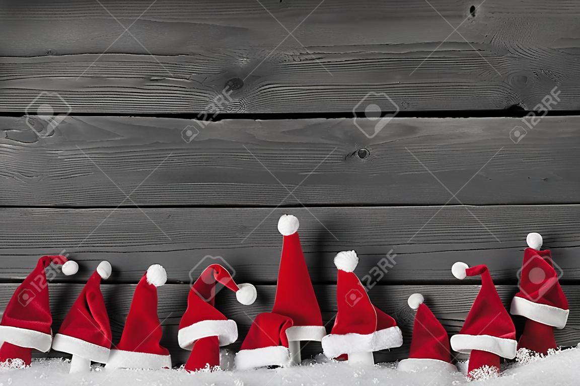 Humoristisch rood, grijs en wit houten kerst achtergrond met kerstmutsen voor een frame.