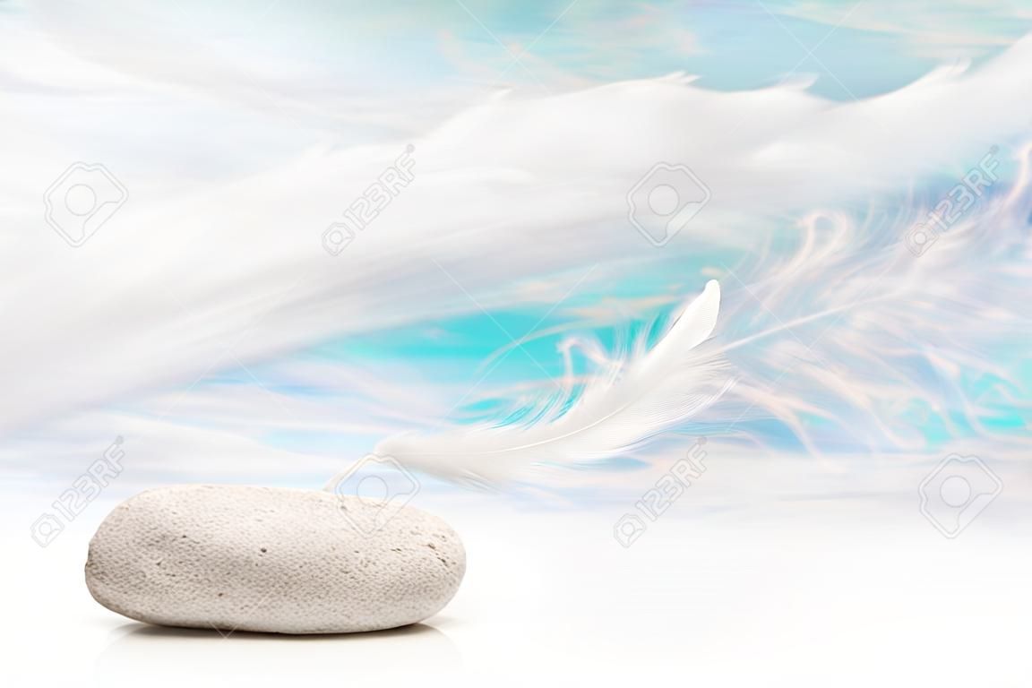 石の上に白い羽: お悔やみやスパのコンセプトの背景。グリーティング カードのためのアイデア。