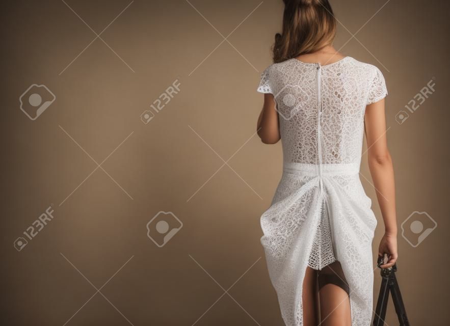 Kobieta w sukience przyłapana w bieliźnie przy użyciu telefonu komórkowego, zdjęcie studyjne
