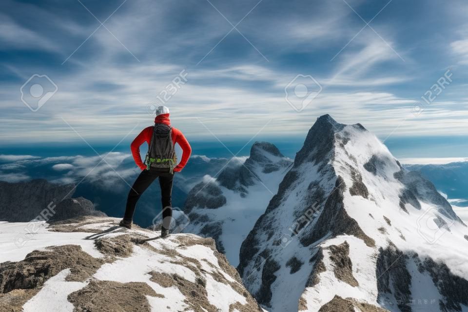 Young hiker standing on mountain range, looking away, Kellenspitze, Tannheim mountains, Tyrol, Austria