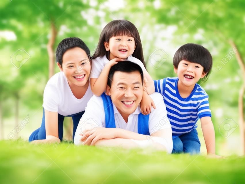 feliz família asiática com duas crianças tirando uma foto de família ao ar livre em um parque.