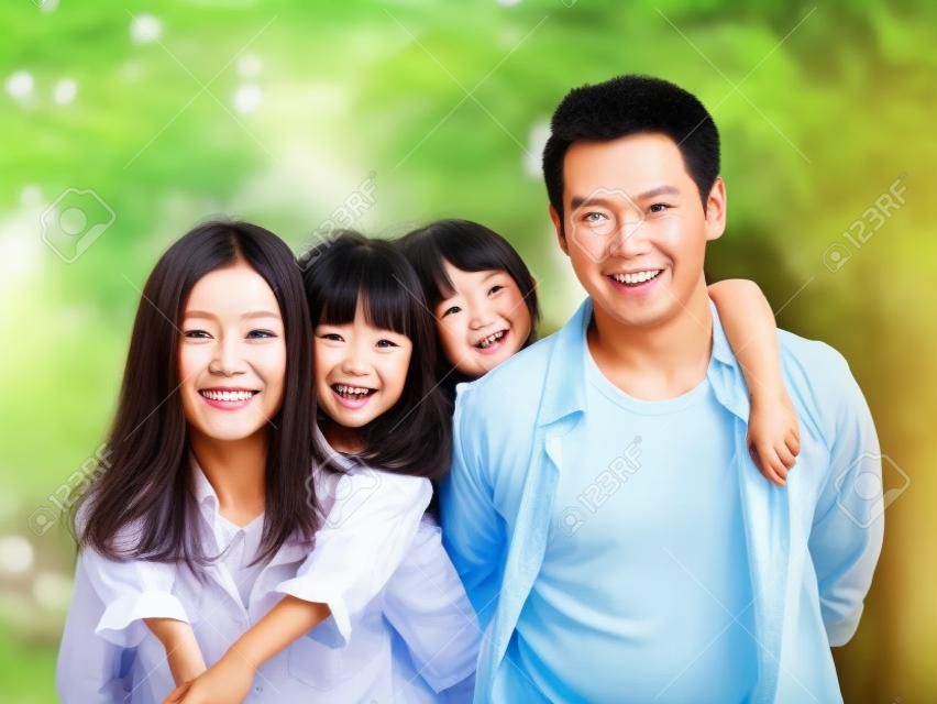 feliz família asiática com duas crianças dando um passeio no parque arborizado.