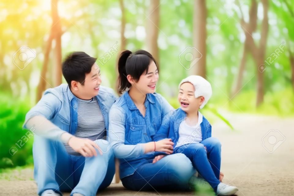 young asian parents and son having fun outdoors in park