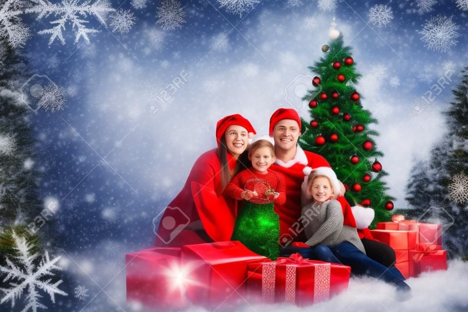 クリスマスの家族の 4 人とモミの木の赤い背景の上のギフト ボックス