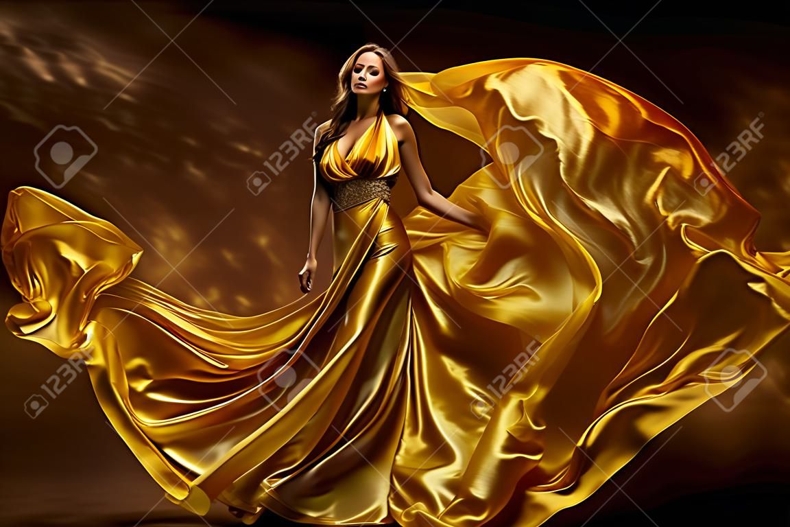 Mode model vrouw jurk, dame in glinsterende zijde schoonheid jurk, stof zwaaien op wind, mooi meisje met lange dynamische vliegende kleding