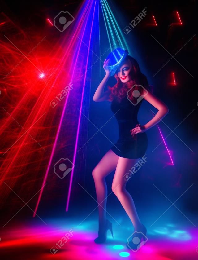 ナイトクラブ ダンスの女の子、夜クラブでダンサー帽子でポーズをとる女性アーティスト輝くミニドレス、レーザー照明照明